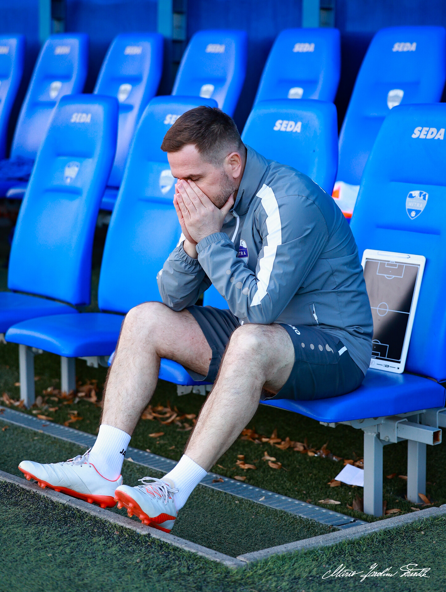 Igor Slezák sediaci na lavičke zamyslený s hlavou v dlaniach